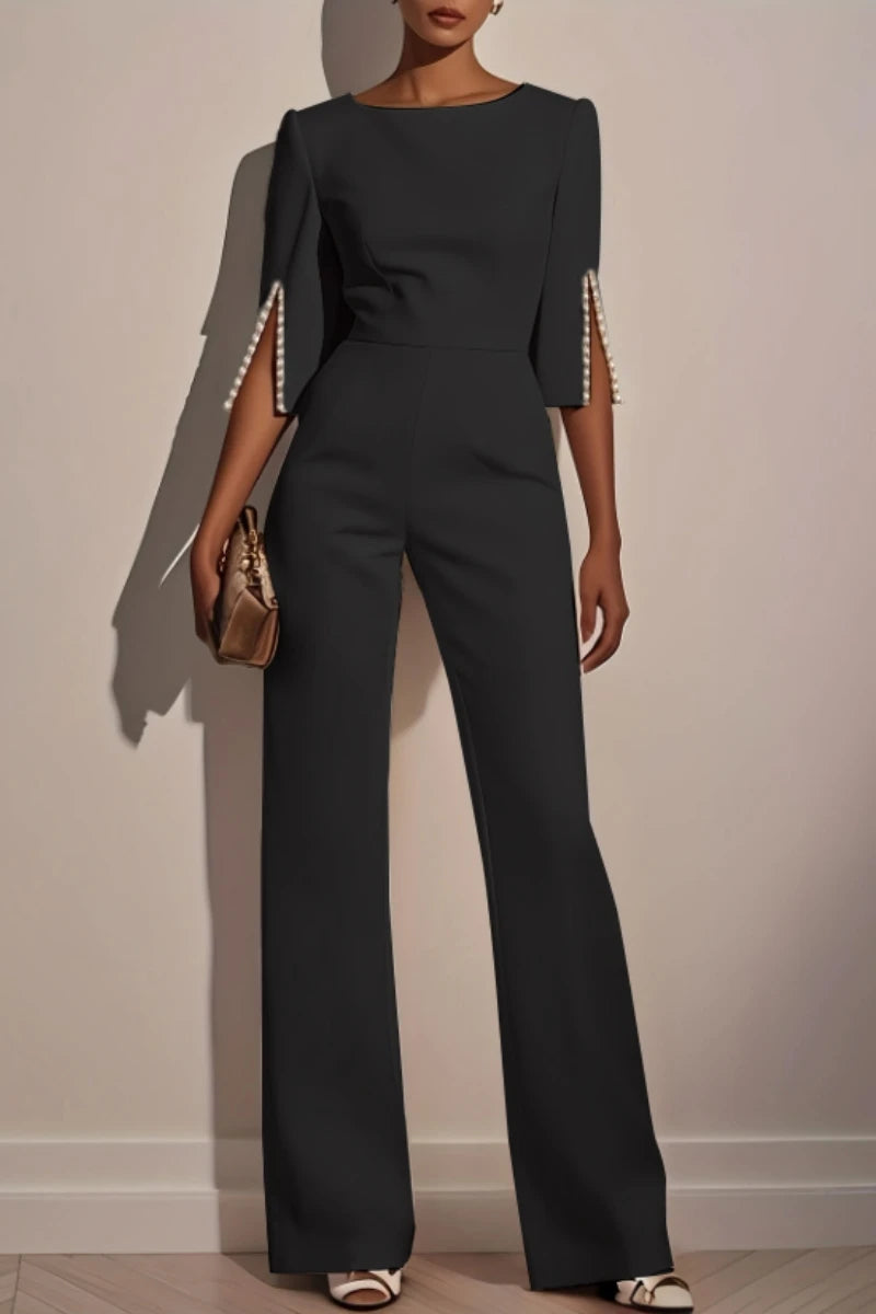 Woman wearing the Celina Studio Étoile Elegance Cape Sleeve Wide-Leg Jumpsuit in Charcoal Gray.