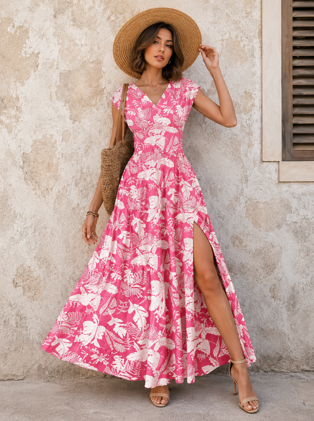 Woman wearing a pink floral print sleeveless maxi dress for summer occasions.