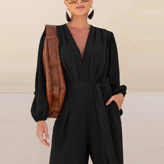 Woman wearing the Celina Studio Élan Wrap Wide-Leg Jumpsuit in Midnight Black with a wrap V-neckline and self-tie waist.
