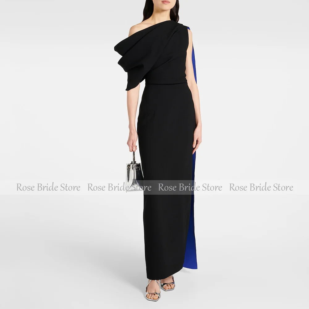 Woman wearing a black one-shoulder cape midi dress for formal occasions.