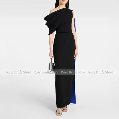 Woman wearing a black one-shoulder cape midi dress for formal occasions.