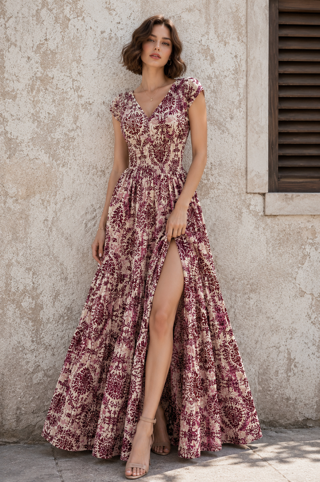 Woman wearing a burgundy floral print sleeveless maxi dress with a feminine silhouette.