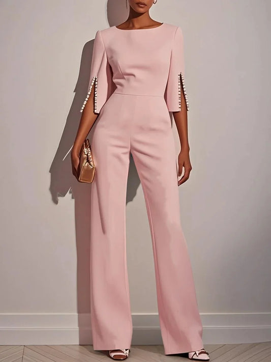 Woman wearing the Celina Studio Étoile Elegance Cape Sleeve Wide-Leg Jumpsuit in Blush Rose.