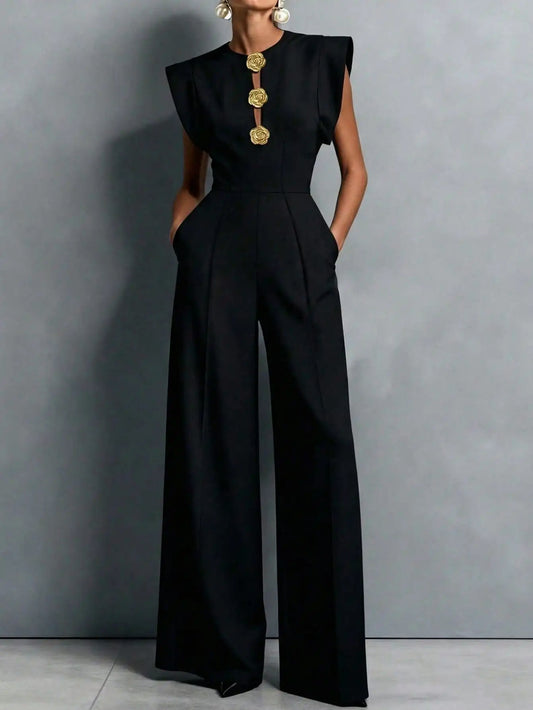 Woman wearing the Celina Studio Noir Luxe Tailored Wide-Leg Jumpsuit in Black with structured shoulders and flowing wide-leg trousers.