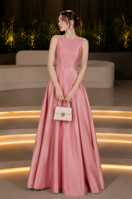 Woman wearing a pink sleeveless A-line maxi gown for weddings and evening events.