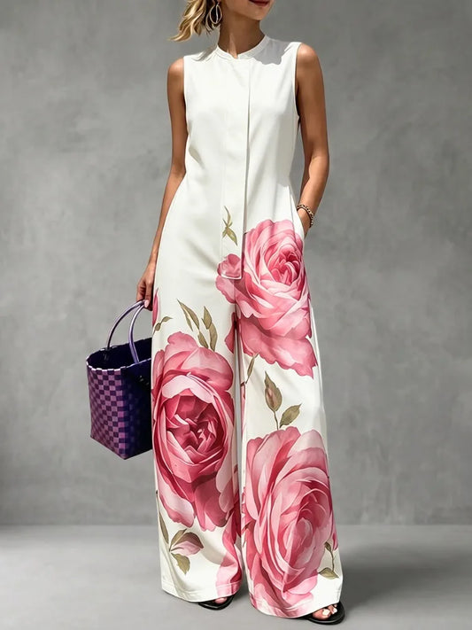 Woman wearing the Celina Studio Rosé Bloom Sleeveless Wide-Leg Jumpsuit with oversized pink floral print, front view.