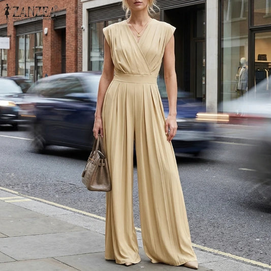Woman wearing the Celina Studio Verona Drape Wide-Leg Jumpsuit in Champagne with a draped V-neckline and flowing wide-leg silhouette.