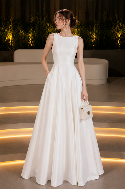 Woman wearing a white sleeveless A-line maxi gown for formal occasions.