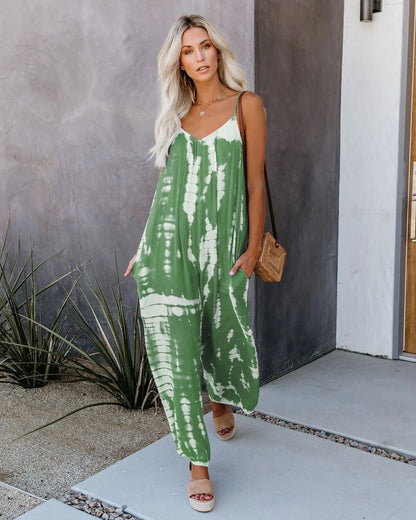 Woman wearing the Celina Studio Isla Breeze Printed Wide-Leg Jumpsuit in Emerald Green with adjustable spaghetti straps and a relaxed wide-leg silhouette.