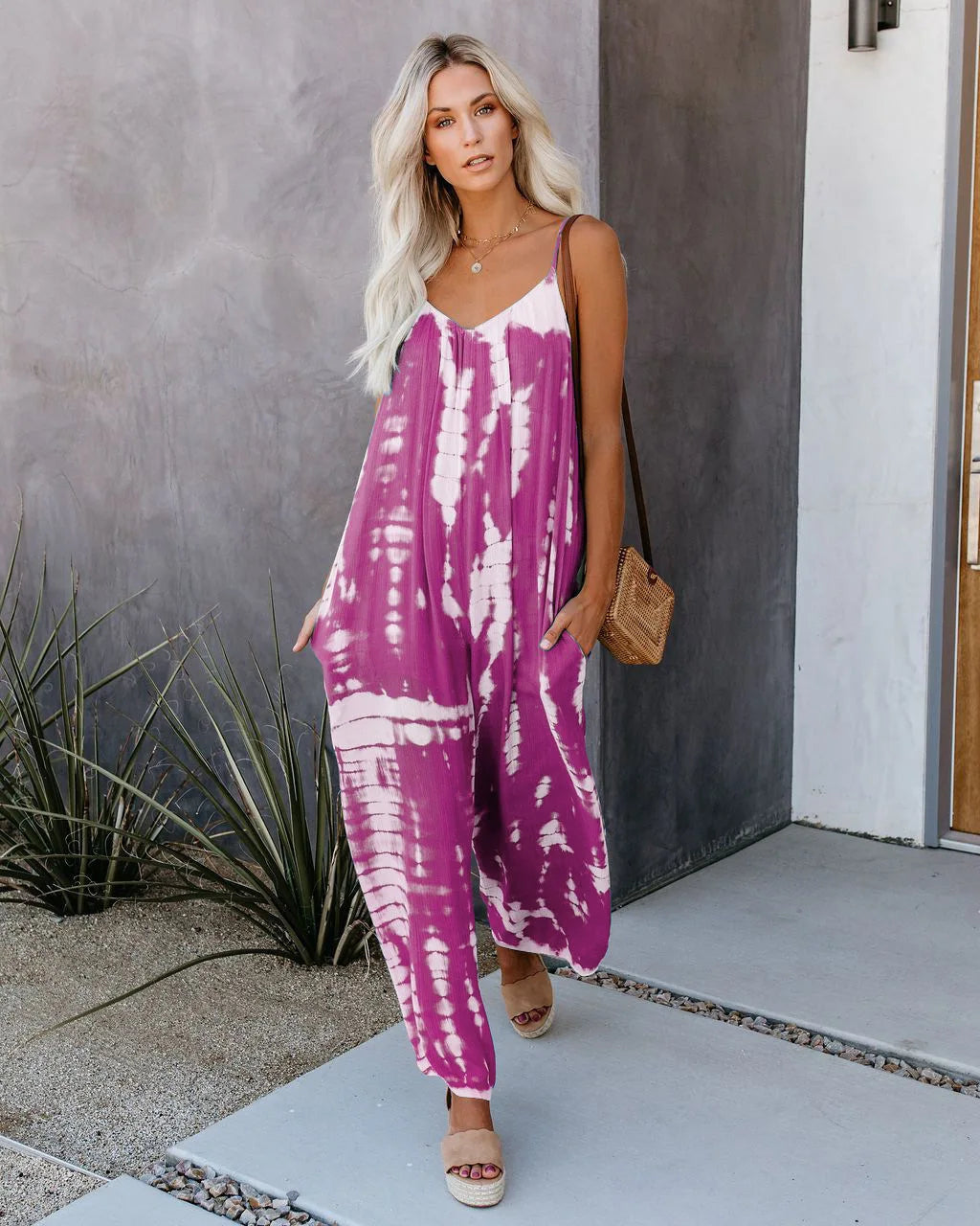 Woman wearing the Celina Studio Isla Breeze Printed Wide-Leg Jumpsuit in Royal Purple with adjustable spaghetti straps and a relaxed wide-leg silhouette.