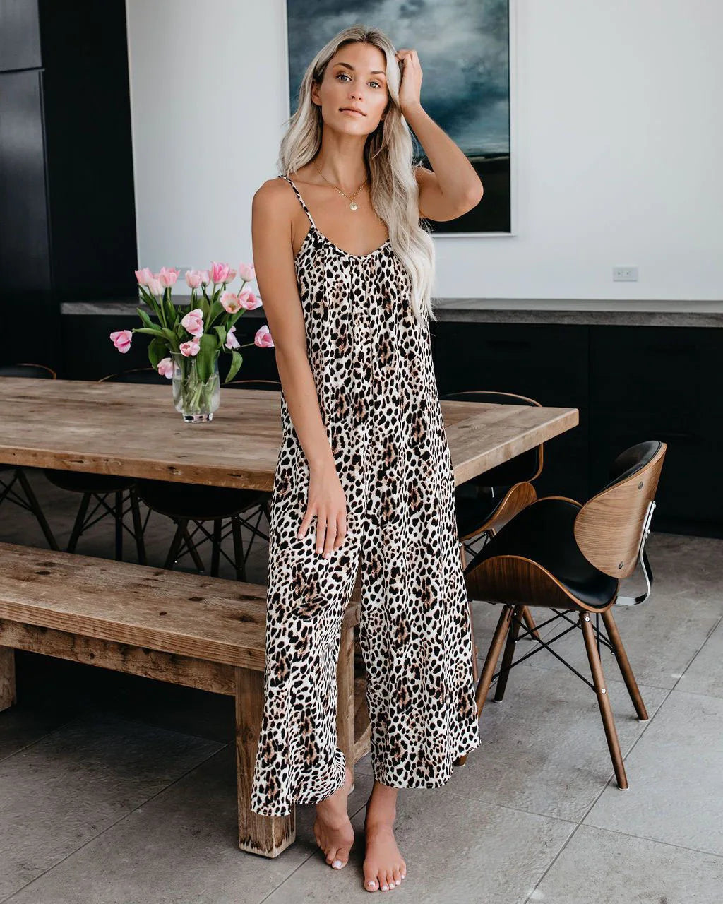 Woman wearing the Celina Studio Isla Breeze Printed Wide-Leg Jumpsuit in Sand Beige with adjustable spaghetti straps and a relaxed wide-leg silhouette.