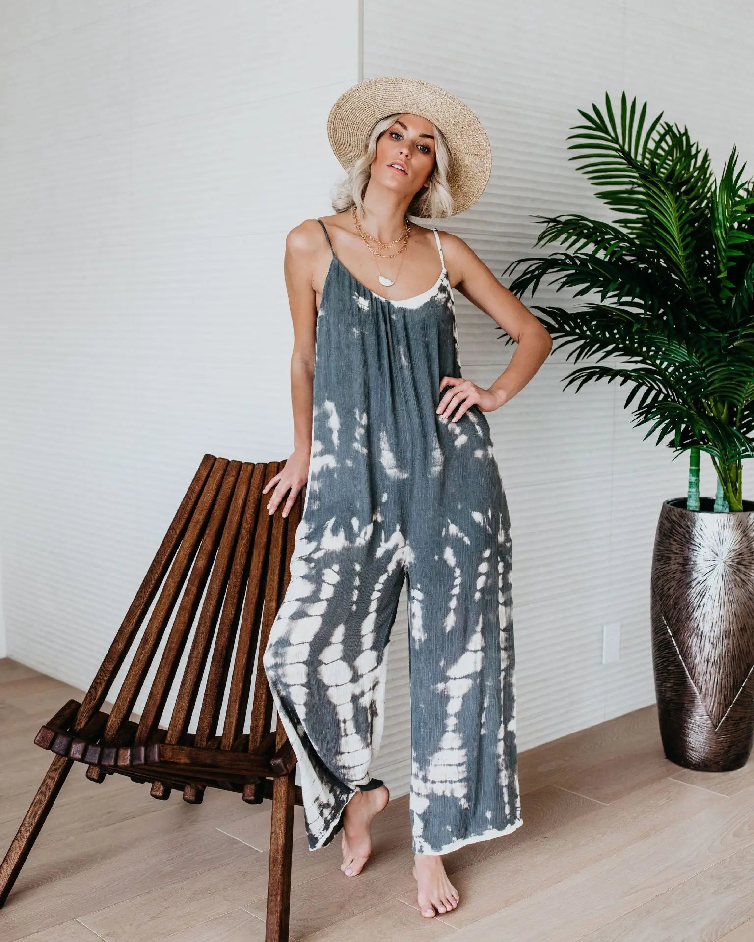 Woman wearing the Celina Studio Isla Breeze Printed Wide-Leg Jumpsuit in Slate Gray with adjustable spaghetti straps and a relaxed wide-leg silhouette.
