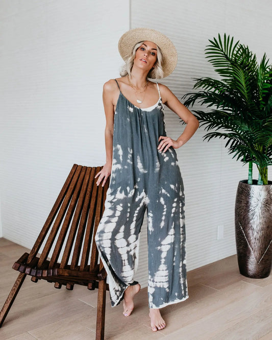Woman wearing the Celina Studio Isla Breeze Printed Wide-Leg Jumpsuit in Slate Gray with adjustable spaghetti straps and a relaxed wide-leg silhouette.